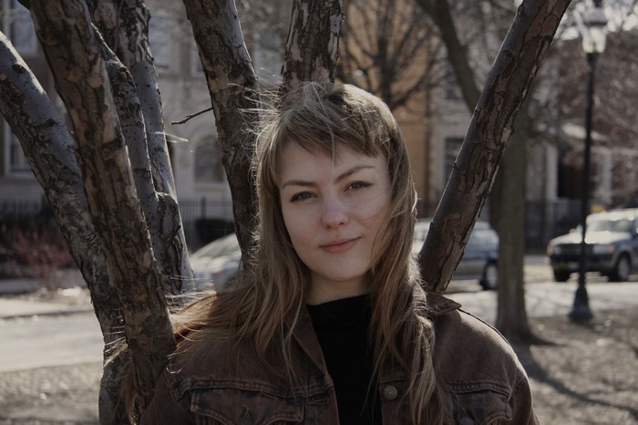 Angel Olsen standing by trees
