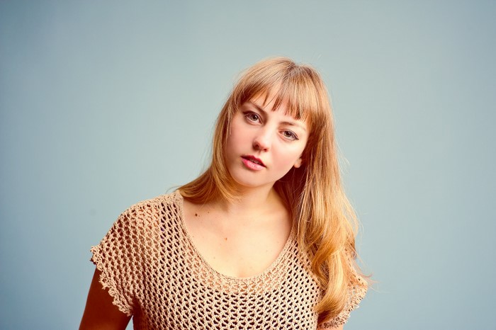 Angel Olsen portrait with blonde hair and mesh top