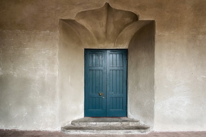 Blue double doors with decorative archway and stone steps