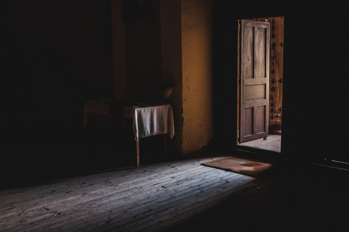 Dark room with wooden door and table