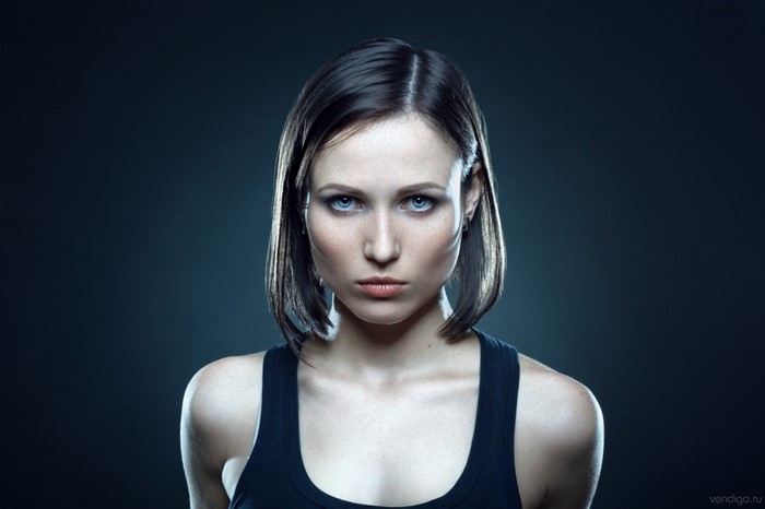Woman with blue eyes and brown hair wearing a black tank top