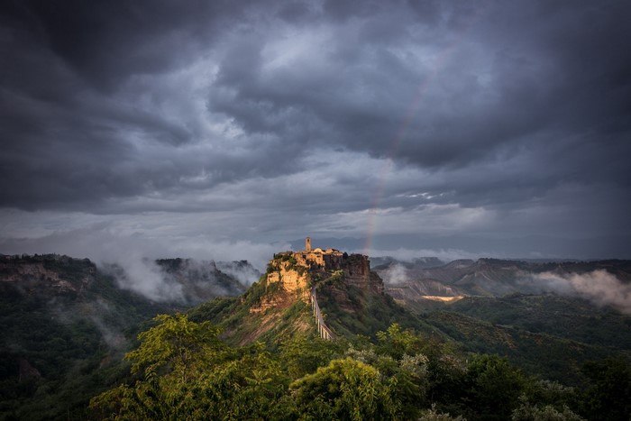 Civita di Bagnoregio, Italy, under stormy skies with a rainbow