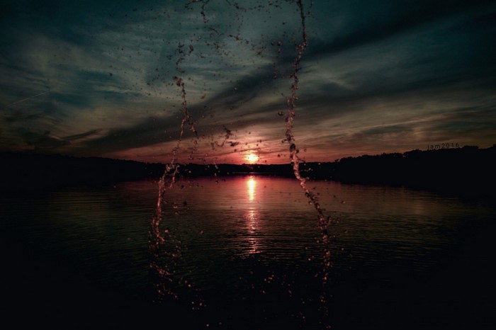 Sunset over a lake with water splashes