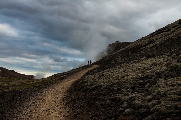 Couple walking on a path in a volcanic landscape