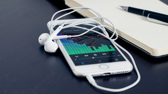 iPhone with earphones and audio spectrum