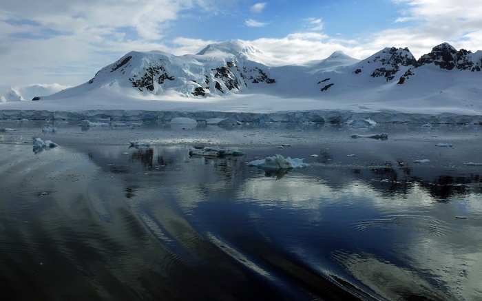 Snow-covered mountains and icebergs in the ocean