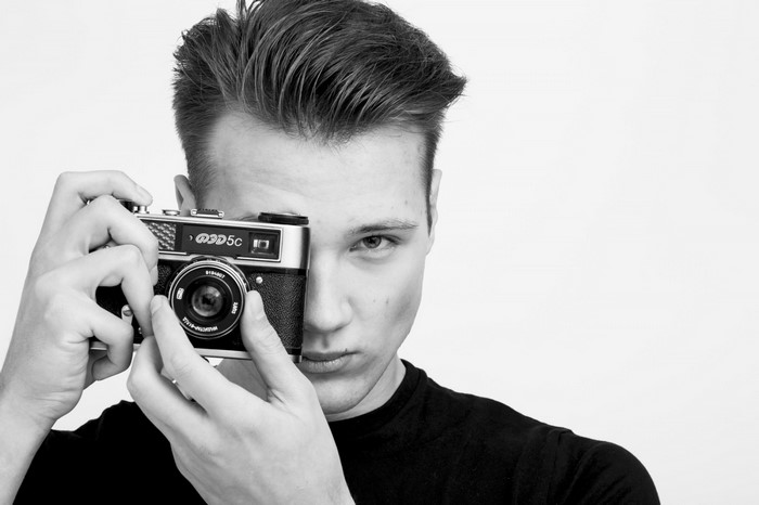 Man holding a vintage camera to his face