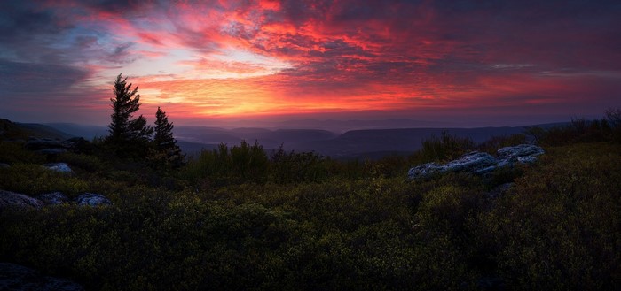 Sunset over mountains with trees and rocks