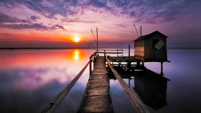 Wooden pier and fishing hut at sunset over the sea