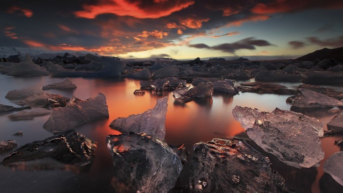 Icebergs floating in water at sunset