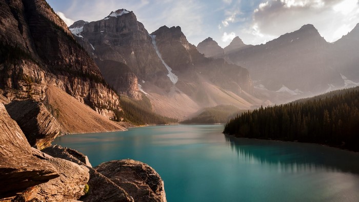 Turquoise lake surrounded by mountains and pine forest