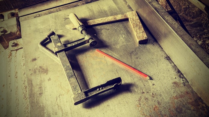 Carpenter's clamp and pencil on a workbench