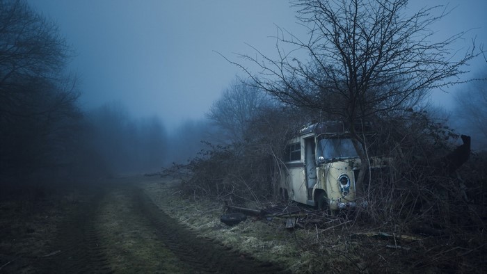 Abandoned van in a foggy forest