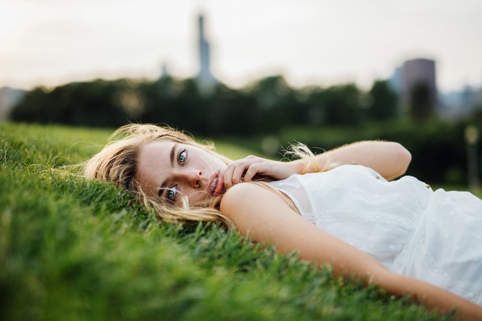 Woman lying on grass in a white dress