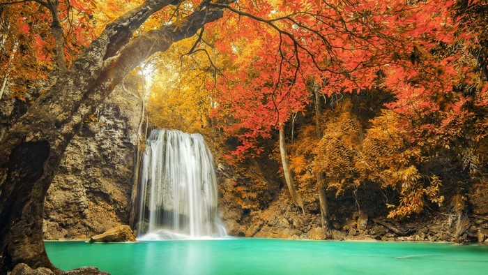 Waterfall in autumn forest with turquoise water