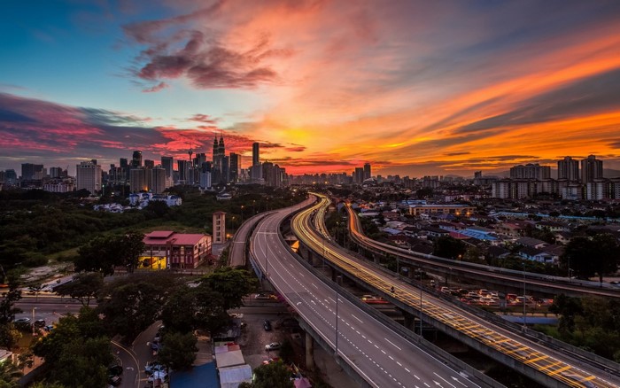 Kuala Lumpur cityscape at sunset with highway and skyscrapers