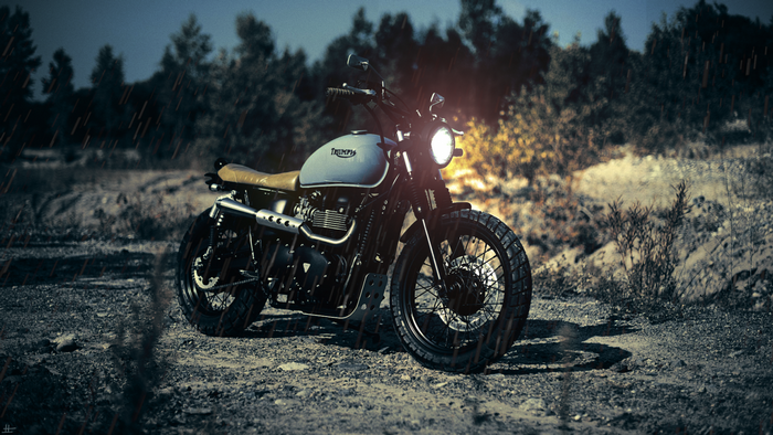 Triumph motorcycle parked on a dirt road in the rain