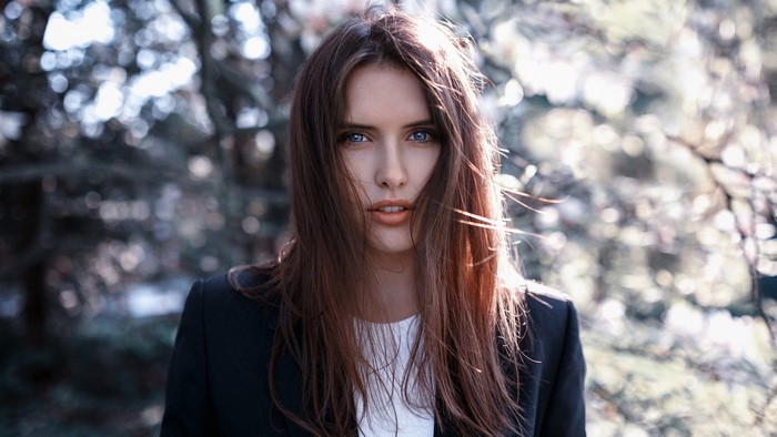 Woman with long brown hair wearing a black blazer