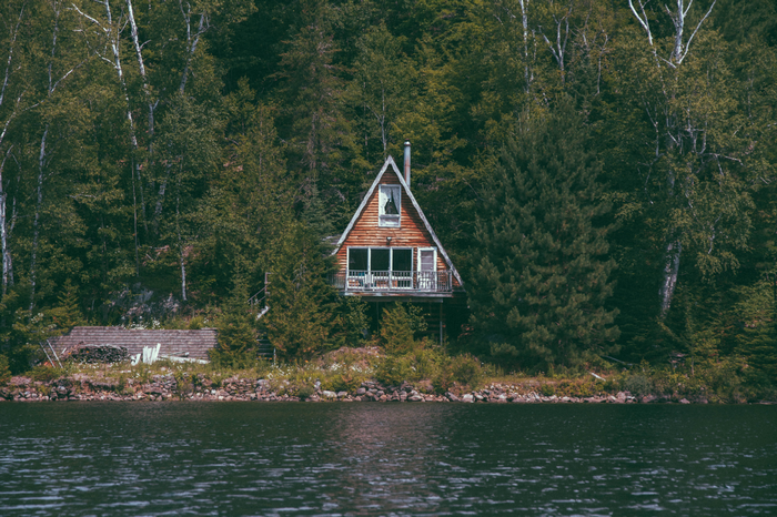 A-frame cabin by a lake in a forest
