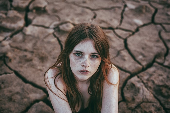 Woman with freckles in cracked earth