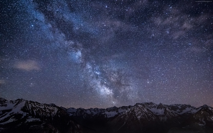 Milky Way over snow-capped mountains at night