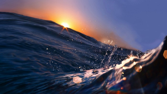 Sunset over ocean waves with sun rays