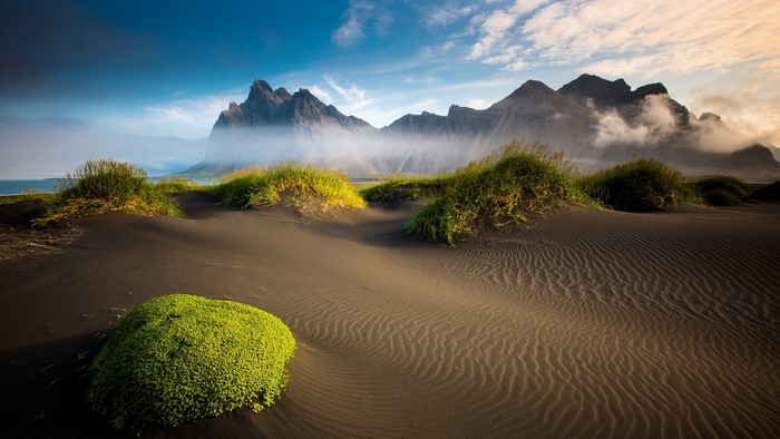 Black sand dunes and mountains at sunrise