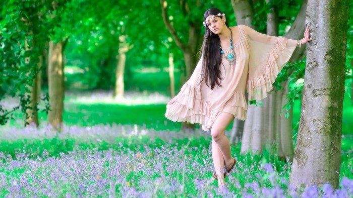 Woman in a flowing dress in a bluebell meadow