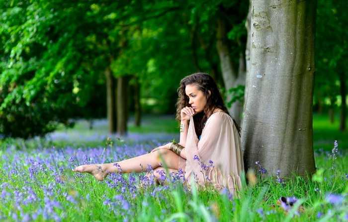 Woman sitting in a field of blue flowers