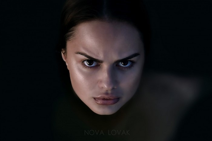 Portrait of a woman with dark hair and intense gaze