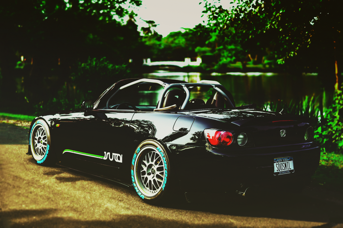 Black Honda S2000 with custom wheels by a lake