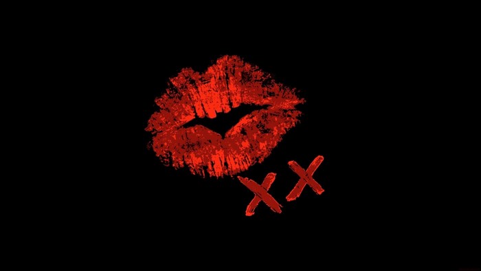 Red lipstick kiss mark and XX on black background