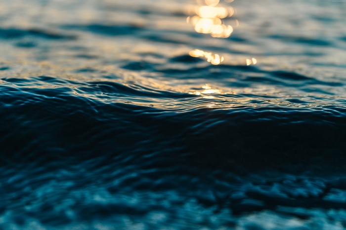 Blue ocean water with sunlight reflections 4K