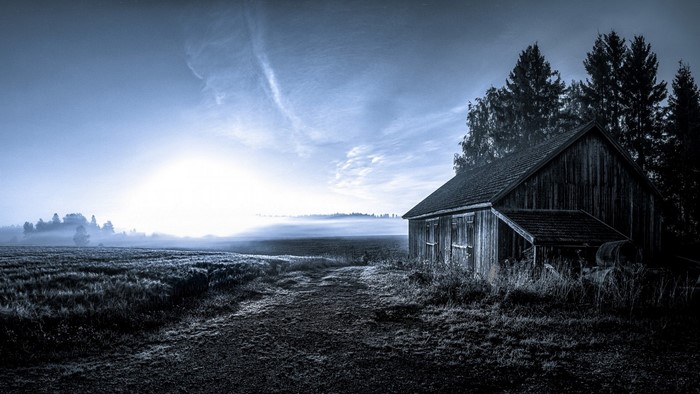 Barn in a misty field at sunrise