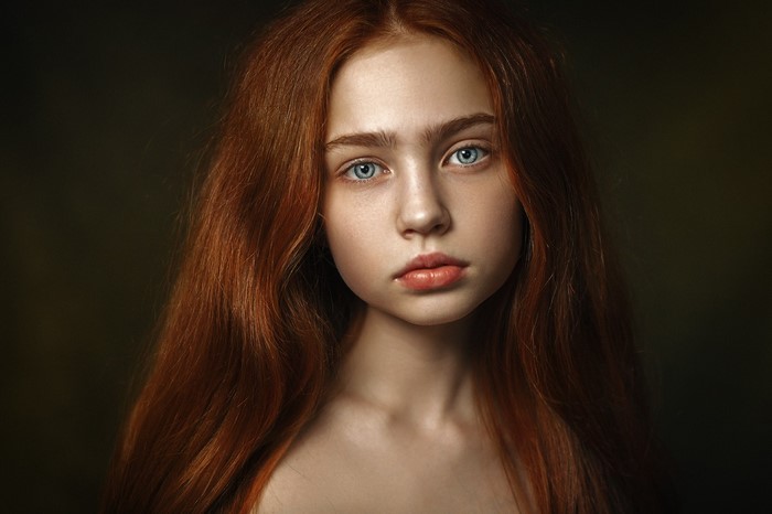 Portrait of a young redhead girl with blue eyes