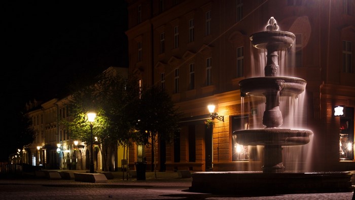 Night street with fountain and illuminated buildings