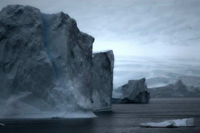 Icebergs in the ocean under a cloudy sky