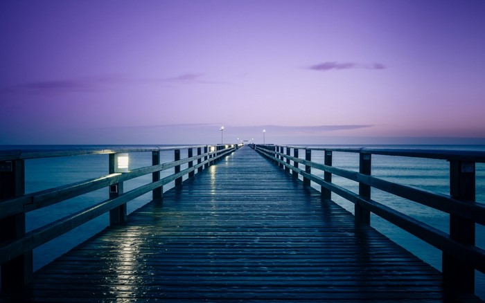 Wooden pier over the ocean at dusk