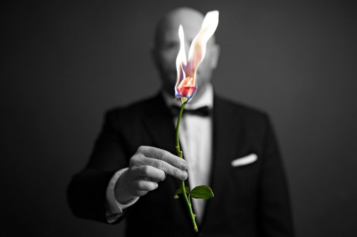 Man in Tuxedo Holding a Burning Rose