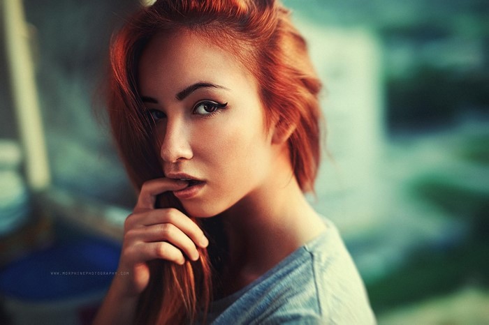 Woman with red hair and finger in mouth