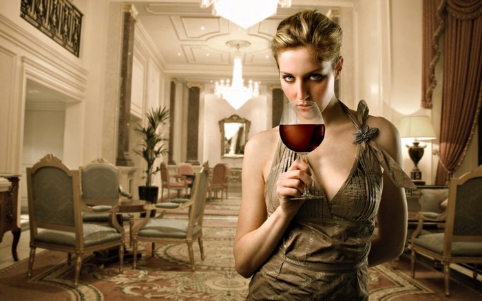 Woman in a dress holding a glass of red wine