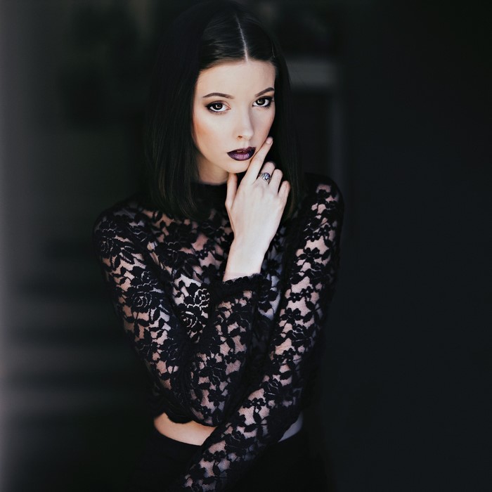 Woman with dark hair wearing a black lace top
