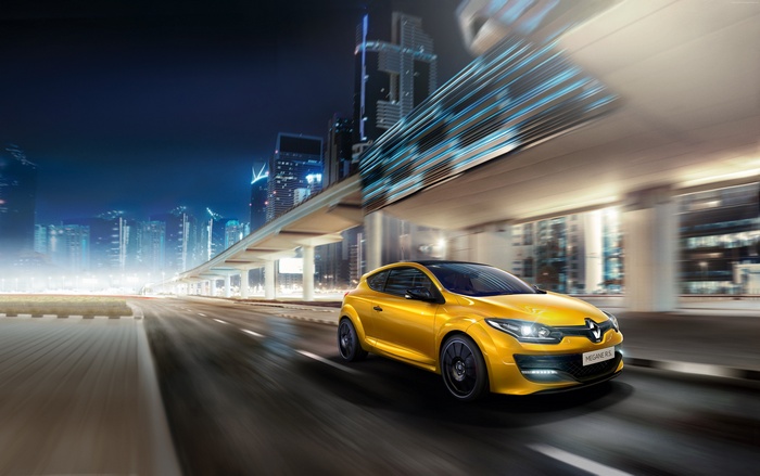 Yellow Renault Megane RS driving in city at night