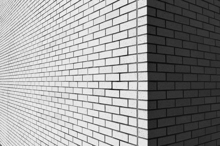 Monochrome brick wall corner with light and shadow