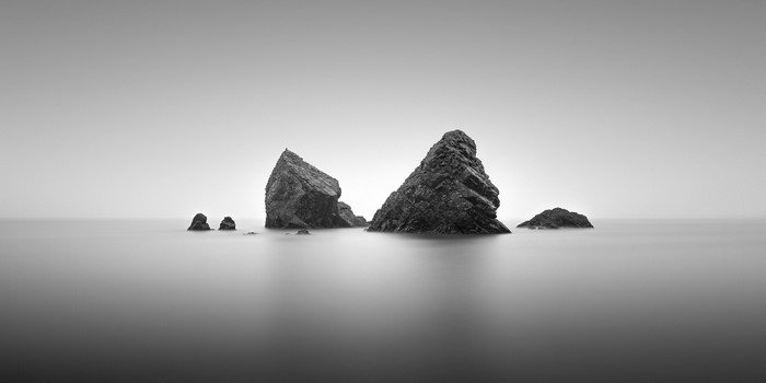 Monochrome seascape with rocks on the horizon