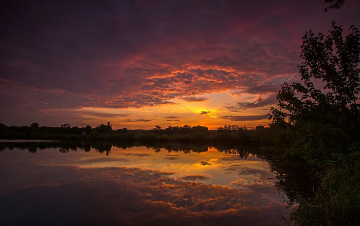 Sunset over a lake with colorful clouds and reflections