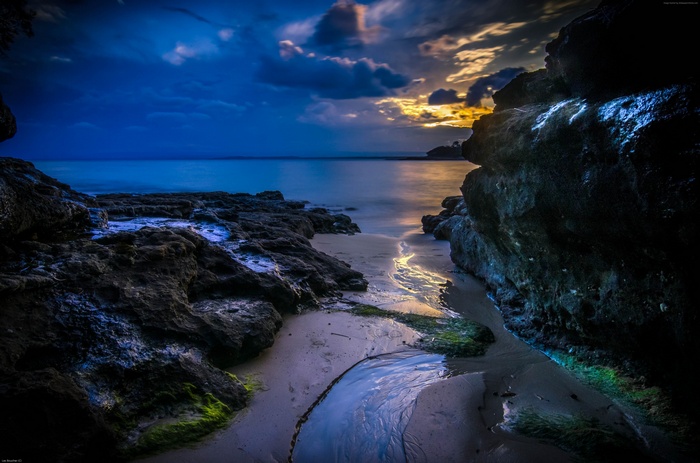 Sunset over the sea with rocky shore