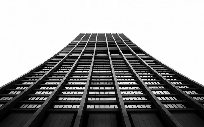Monochrome view of a tall skyscraper from below