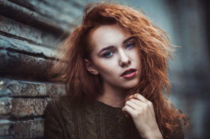 Redhead woman with curly hair in a sweater