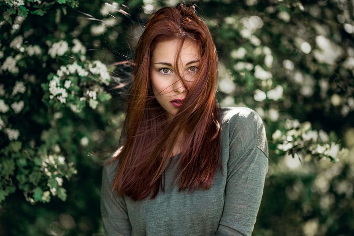 Woman with red hair in a green shirt outdoors